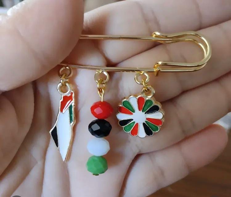 Elde tutulan, figürlerle süslenmiş el yapımı broş