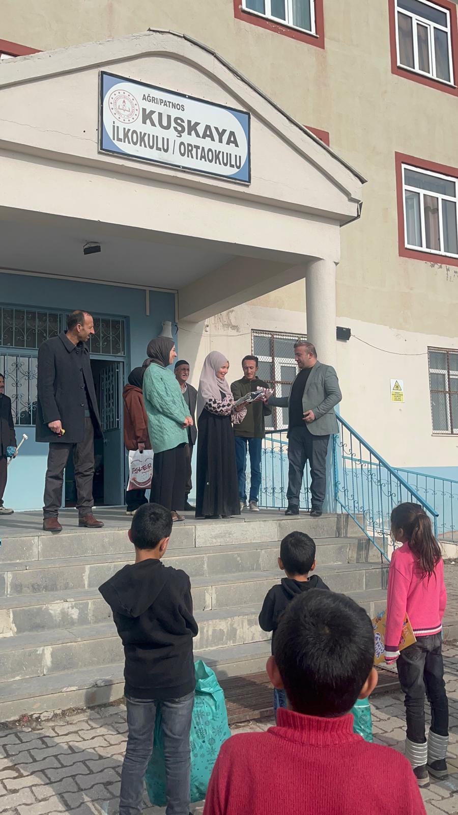 Okul bahçesinde yardım dağıtımına katılan öğrenciler